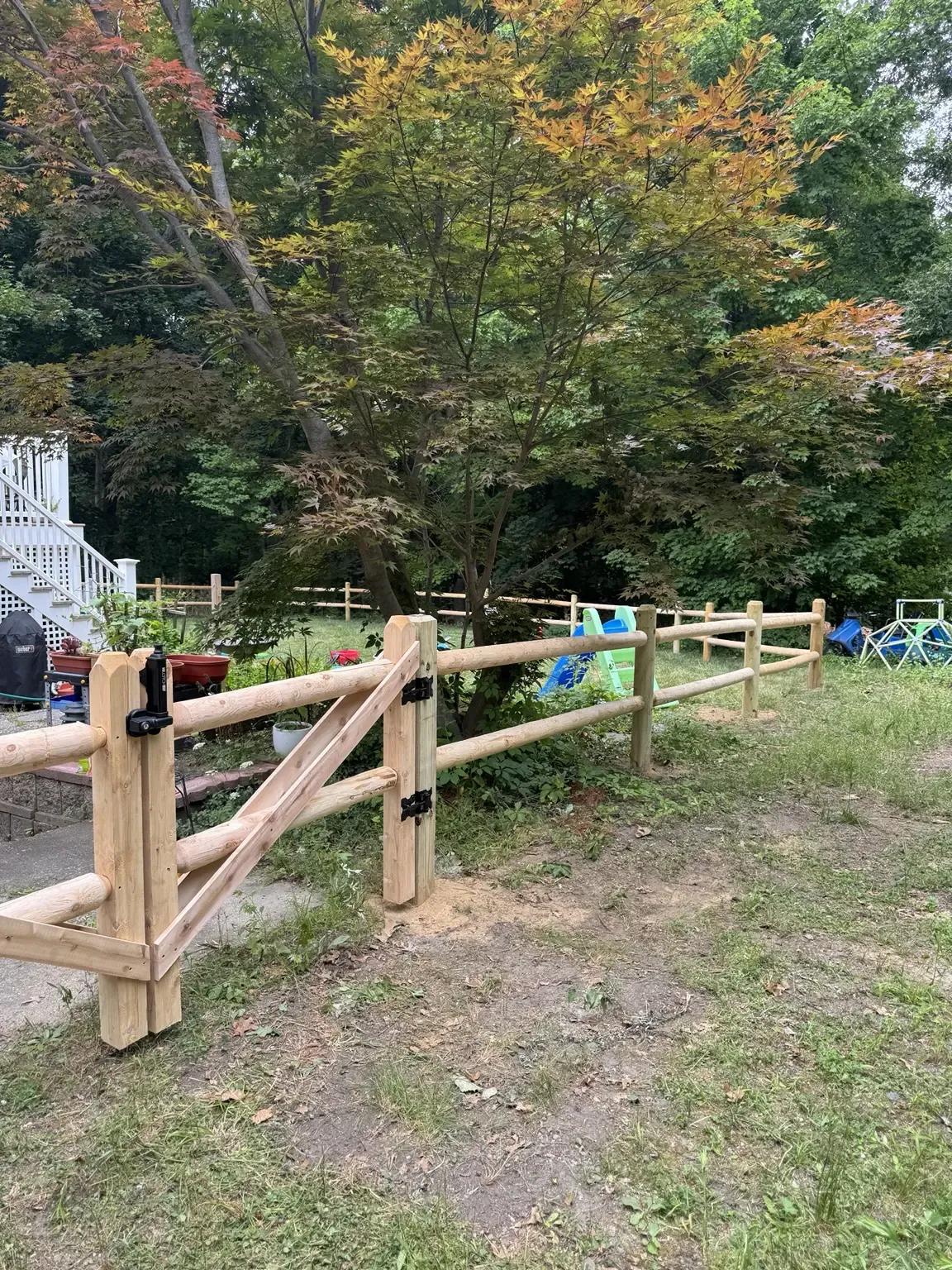 Wood post and rail fence with a matching gate