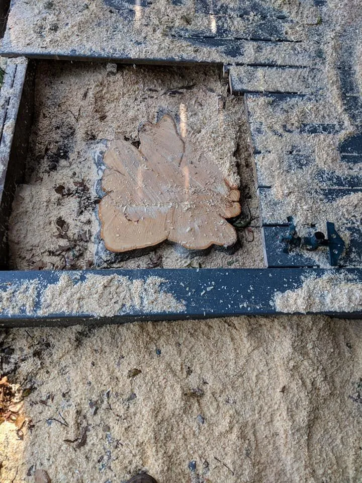 Broken clay tile in a muddy trench with dark framing bars and sand around it