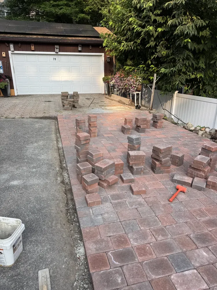 Brick pavers being installed beside a driveway