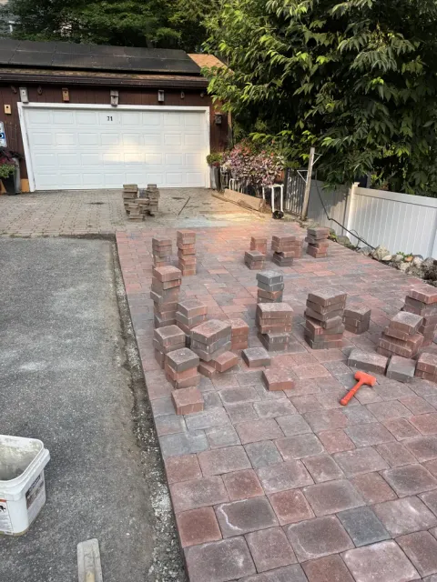 Brick pavers being installed beside a driveway