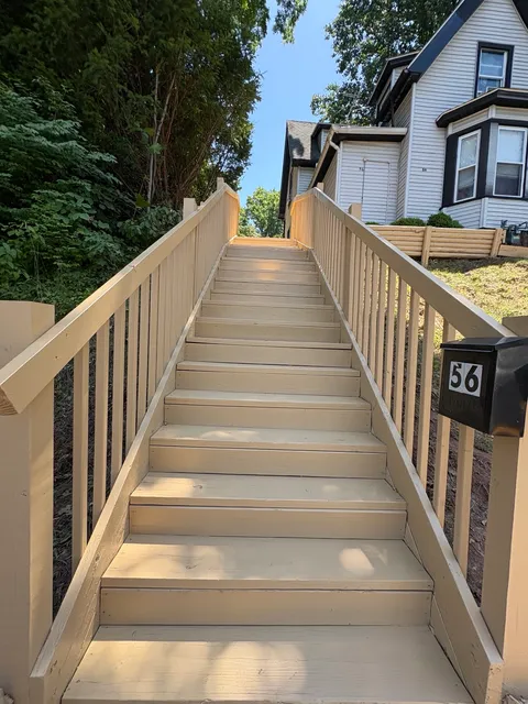 Long finished outdoor wooden stairway with new handrails