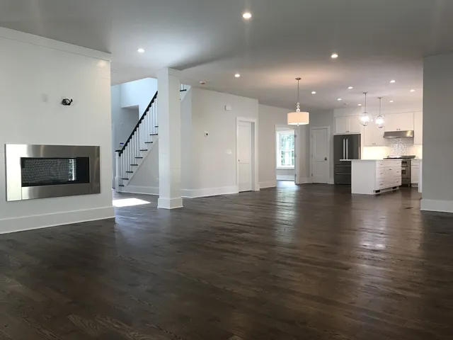 Open great room with shiplap fireplace and custom staircase