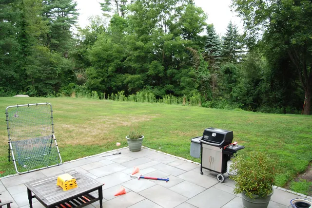 Before photo of Weston backyard with simple patio and lawn prior to landscape renovation