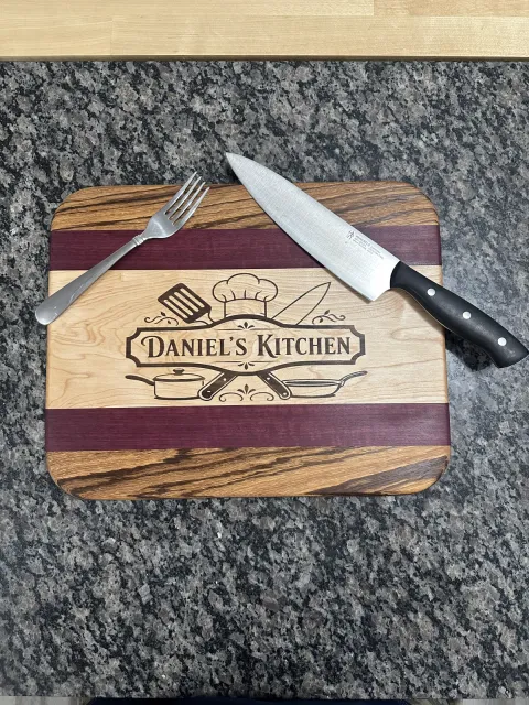 Purpleheart, maple, and zebrawood cutting board with a walnut inlay
