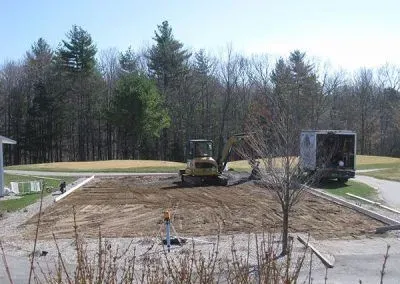 A construction site with a bulldozer and a truck in the background