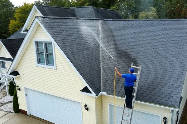 Mansfield Services applying a roof cleaning treatment on a Vermont home
