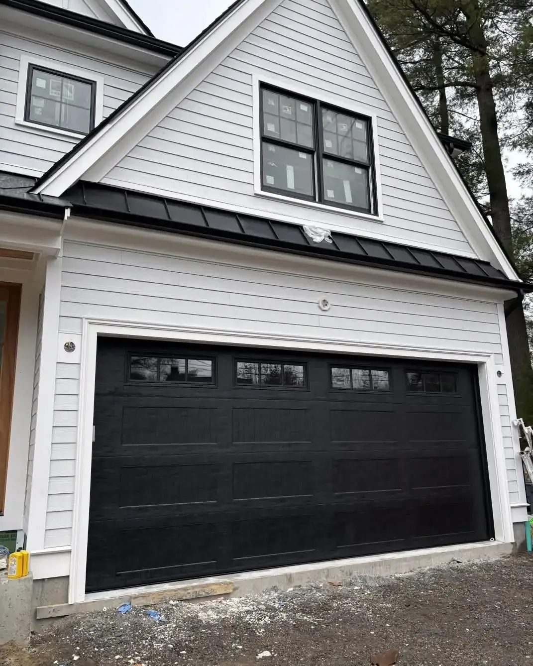 A black carriage-style door with top windows