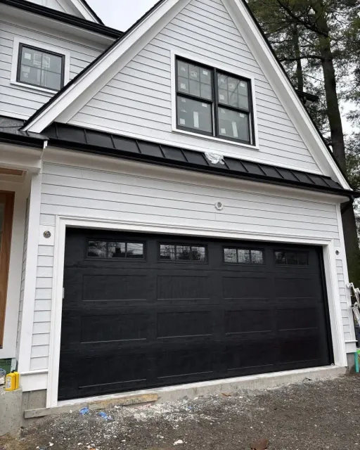 A black carriage-style door with top windows