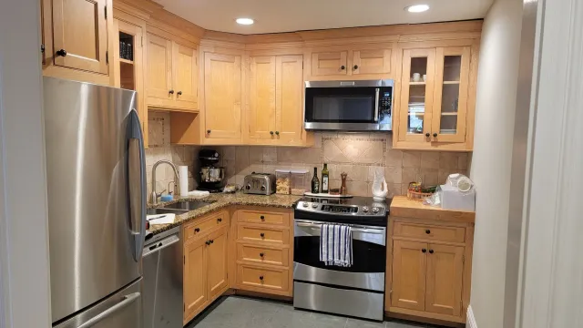 a small kitchen with stainless steel appliances and wooden cabinets