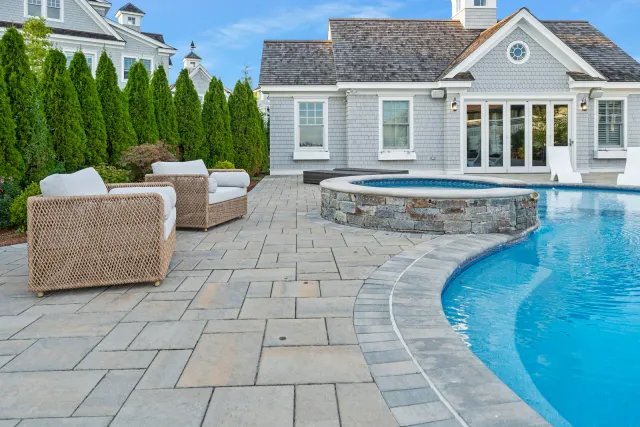 Custom stone patio and pool deck installed by GADE Masonry in Sandwich, Cape Cod MA