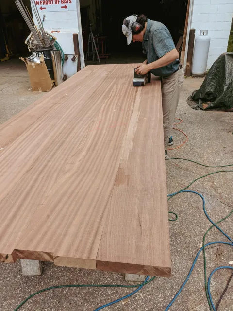 A man sanding down custom millwork at J.P. Smith Builders.