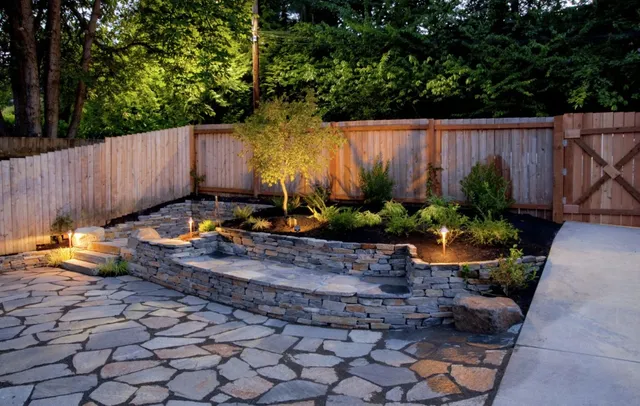 Professional landscape lighting with raised stone walls in Brookline, MA