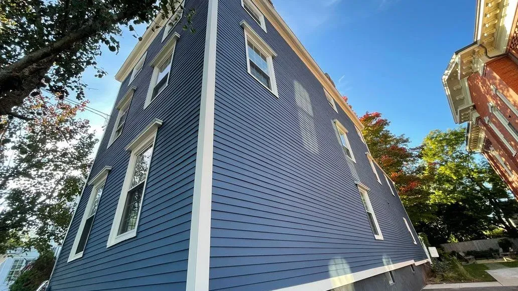 Looking up at a blue building with white trim