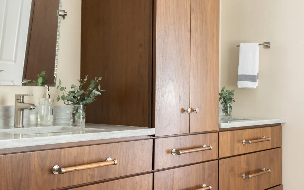 Before photo of bathroom with double-sink wood vanity and marble countertops - Woodland Builders, South Shore MA.