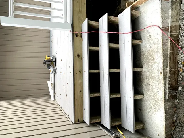 Finished composite deck with white railing overlooking woods