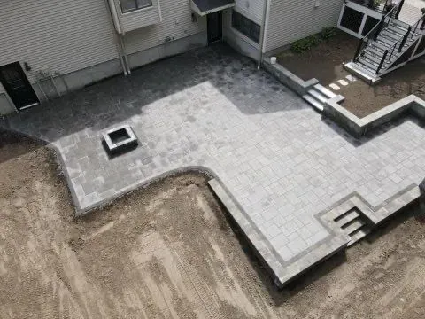An aerial view of a patio being built in front of a house.