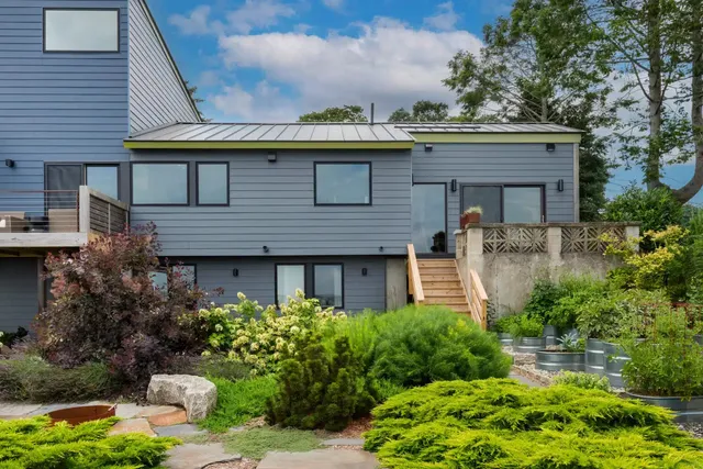 Gray modern home addition exterior with a landscaped garden in Warwick