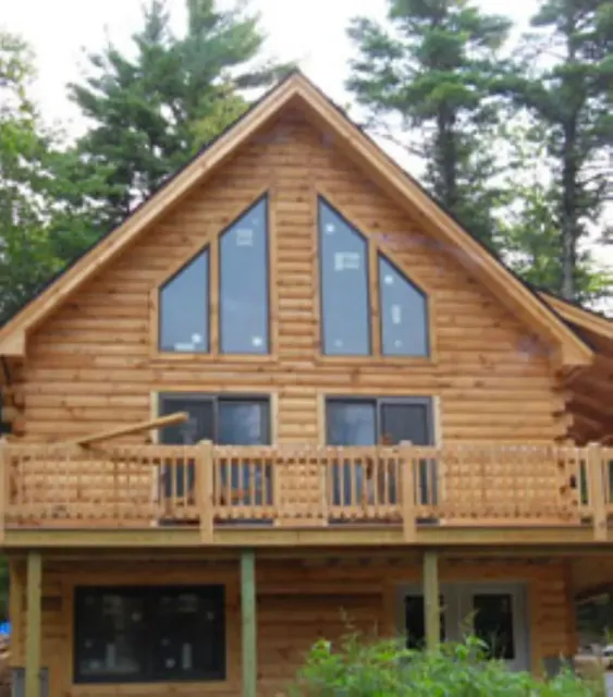 A large log cabin with a balcony and large windows