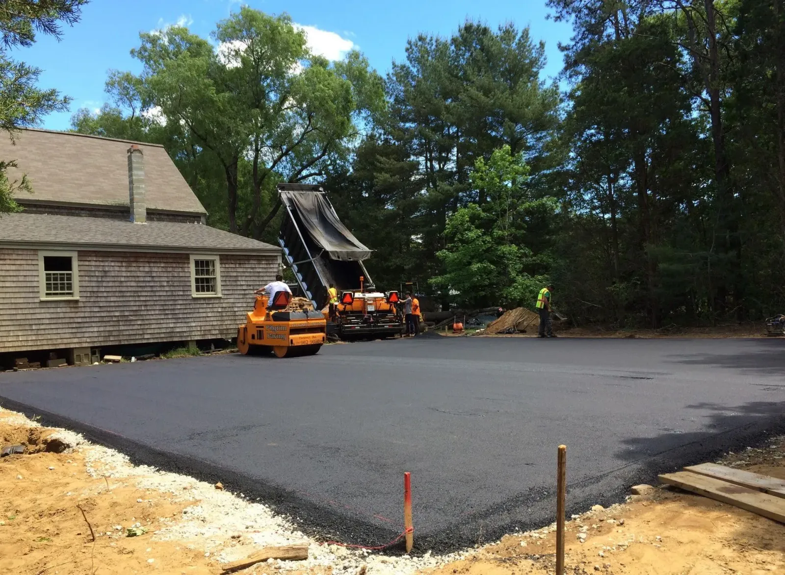 a large amount of asphalt is being rolled out in front of a house