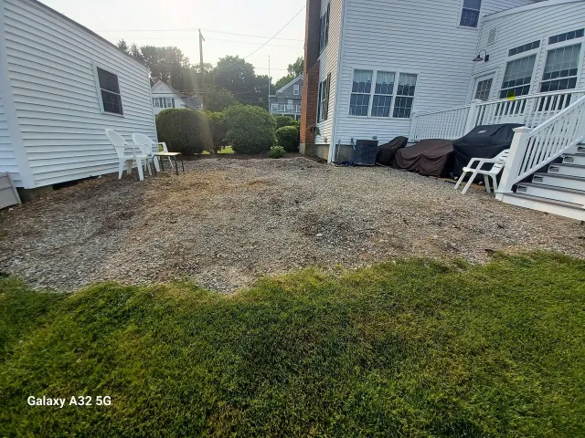 Before: Gravel backyard between house and shed