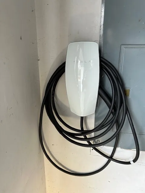 Boston Light & Power electrician installing a Tesla Wall Connector in a garage in Quincy, MA.