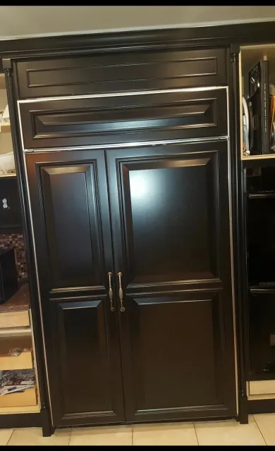 Dark brown paneled double door with brass handles and decorative trim in a wood interior.