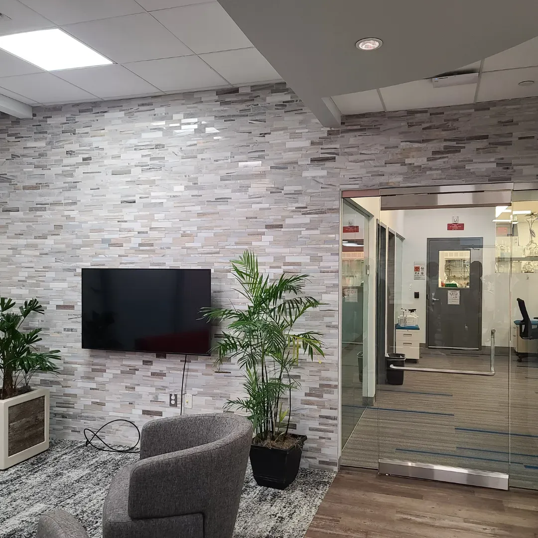 Commercial reception lobby with linear stacked-stone tile feature wall by Link Services Pro in Holden, MA