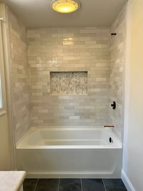 A bathroom with a bathtub and a shower.