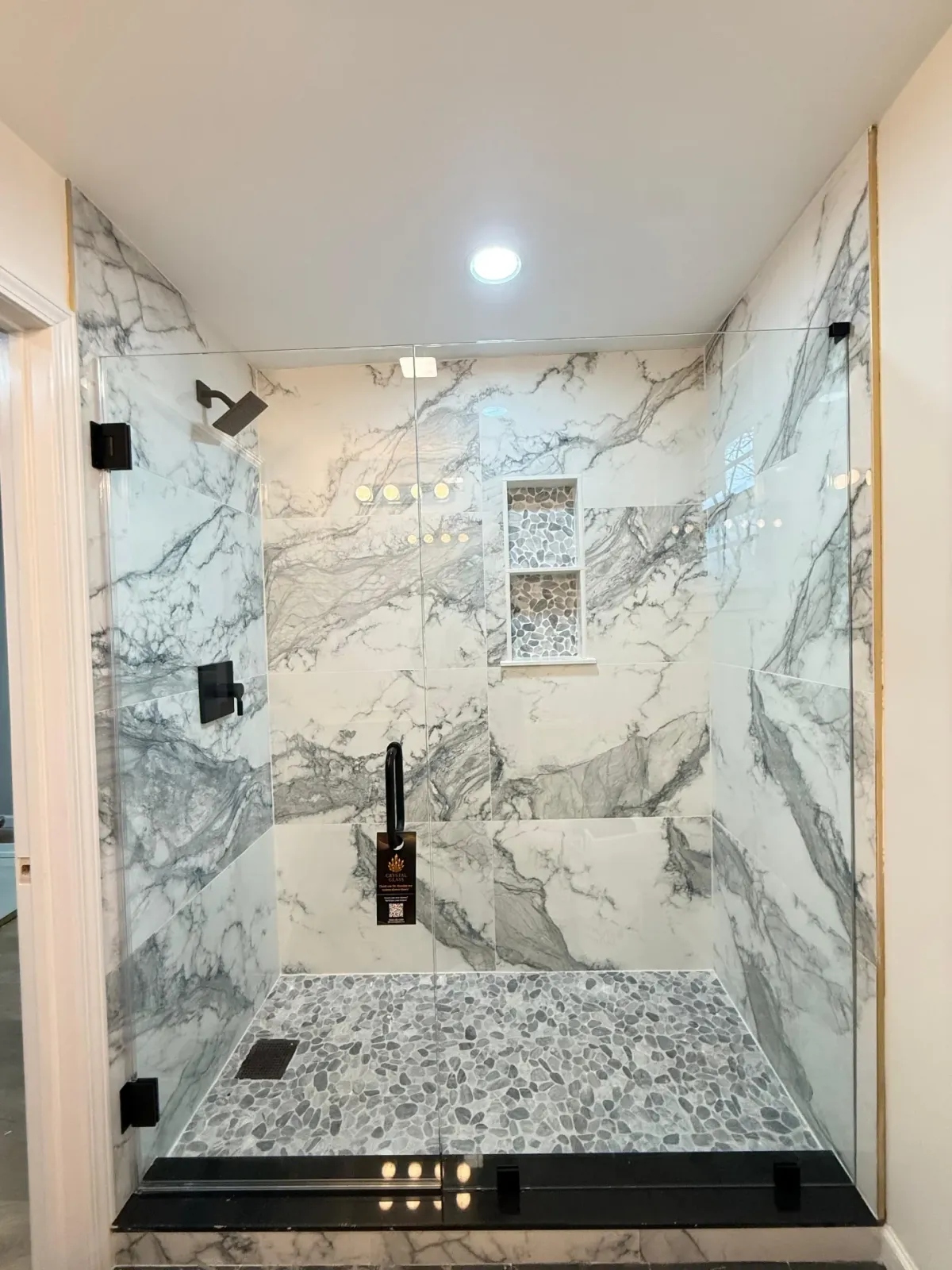 Marble walk-in shower with black hardware