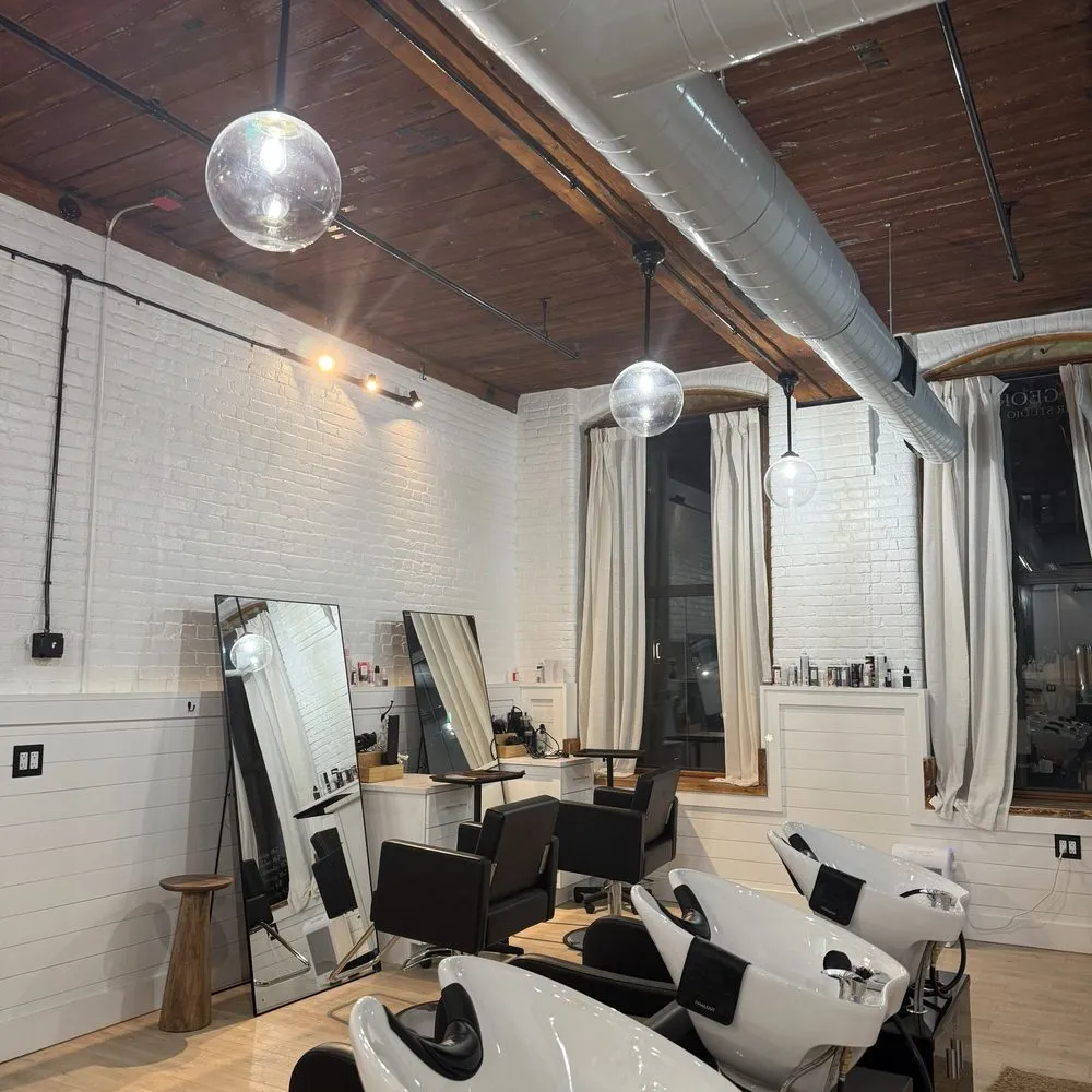 Boston Light & Power electrician installing pendant lighting in a salon in Quincy, MA.