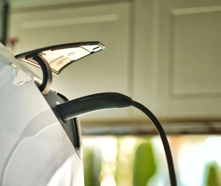 White electric vehicle charging port with sleek curved handle and chrome accents
