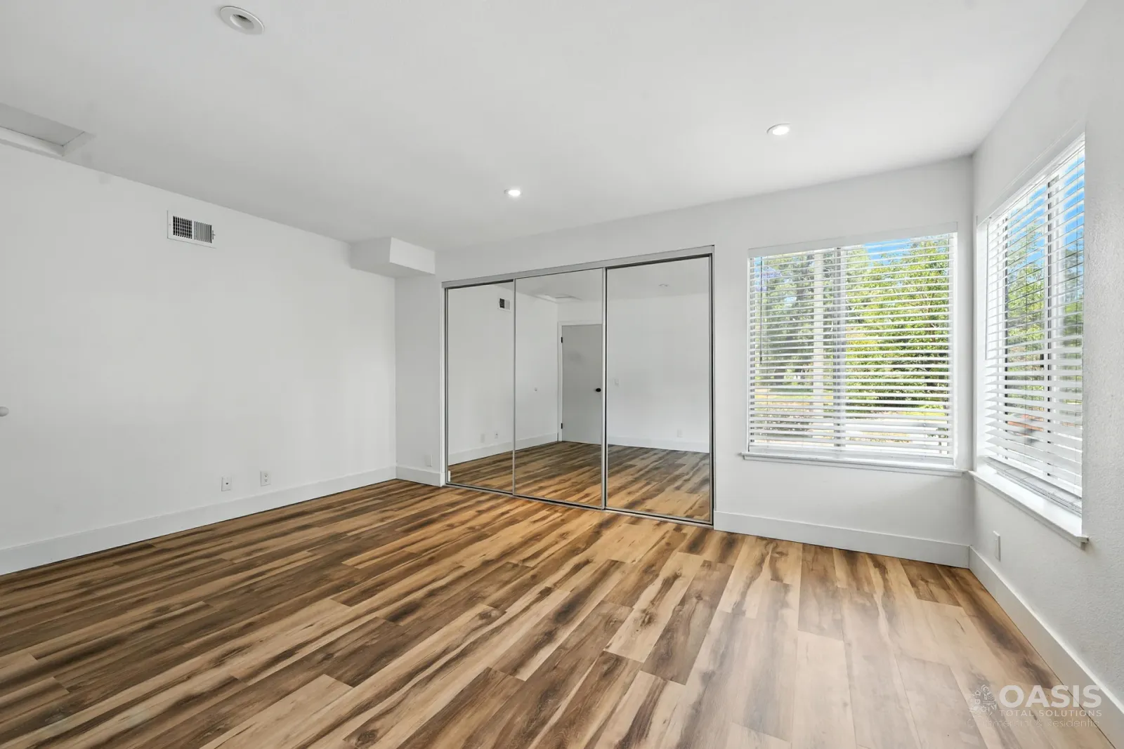 Finished bedroom with new flooring and mirrored closet doors