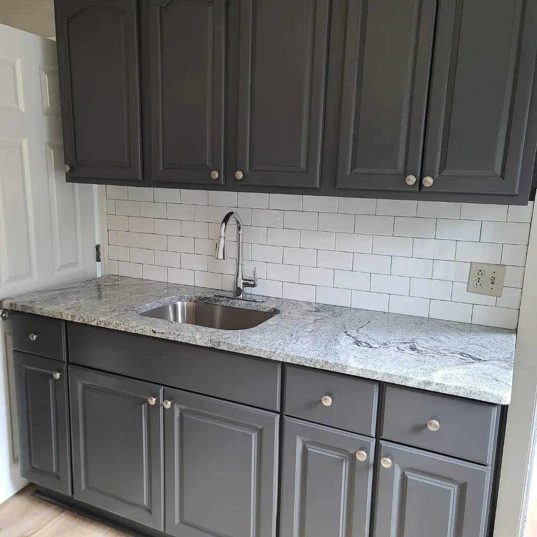 Galley kitchen with gray painted cabinets, white subway tile and viscount granite by Link Services Pro in Auburn, MA