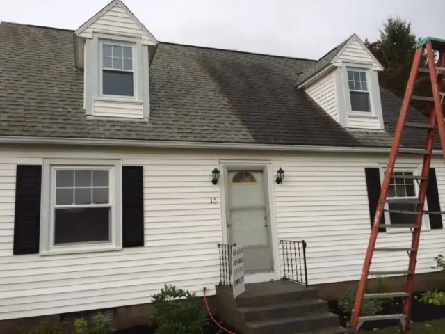 House roof showing side by side before and after roof cleaning