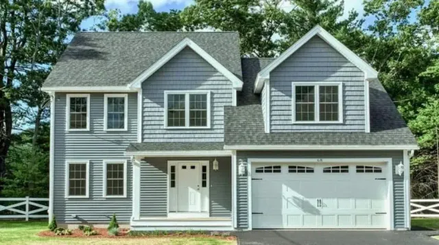 Two-story gray home with gabled roof, white trim, and attached garage, located in the Greater Boston area