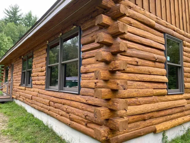 A log cabin with a lot of windows on the side of it.