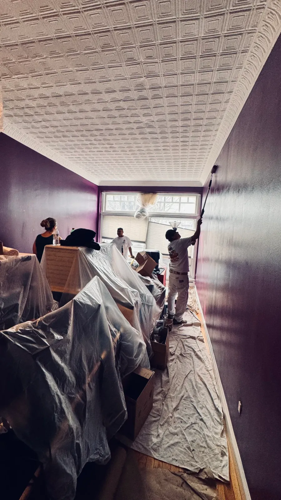 Interior painting service showing protected furniture and freshly painted walls in a Waltham, MA home