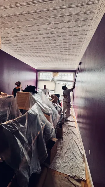 Interior painting service showing protected furniture and freshly painted walls in a Waltham, MA home