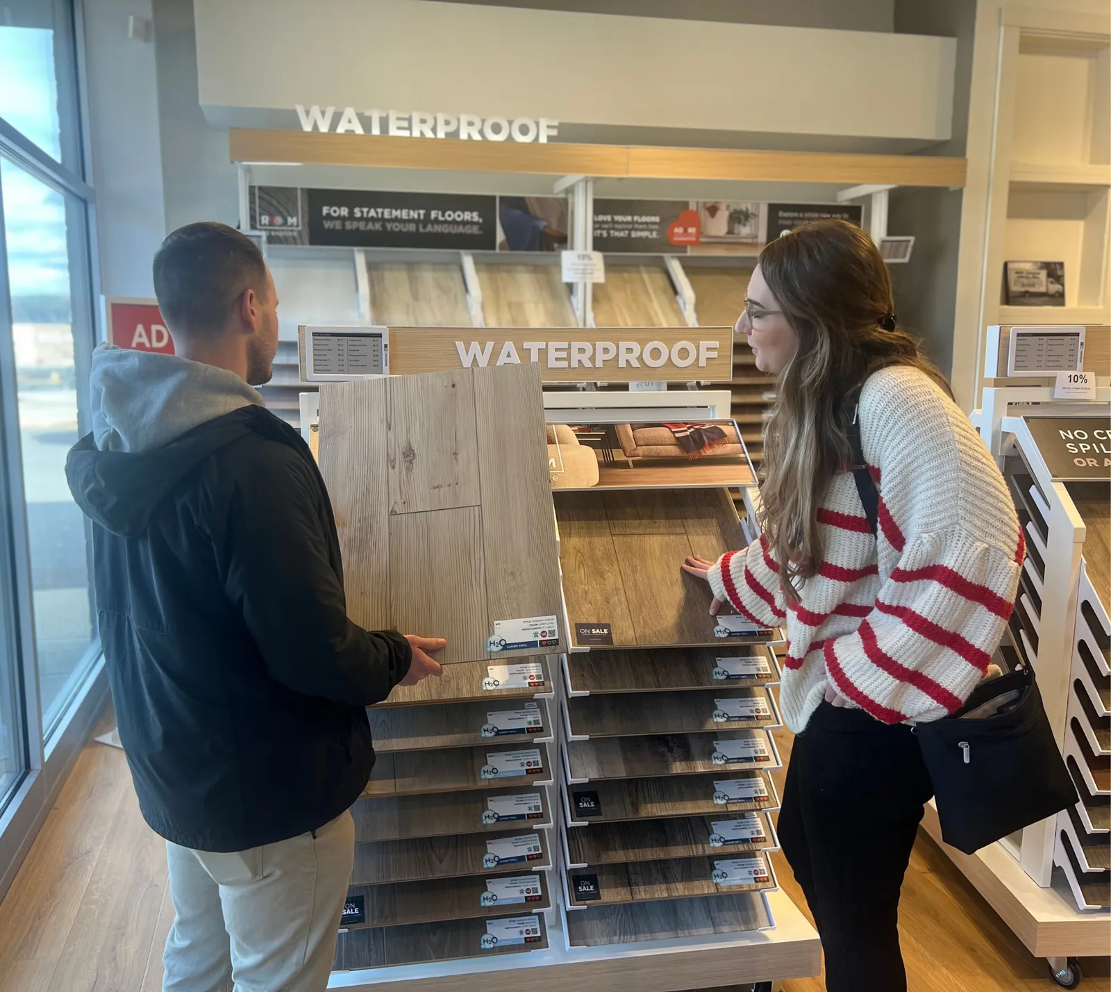 Women holding flooring sample in floor store