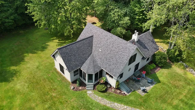 Shingle roof replacement on Vermont country home in Stowe — dark charcoal architectural shingles, complex multi-plane roofline