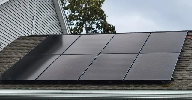 A row of solar panels on the roof of a house