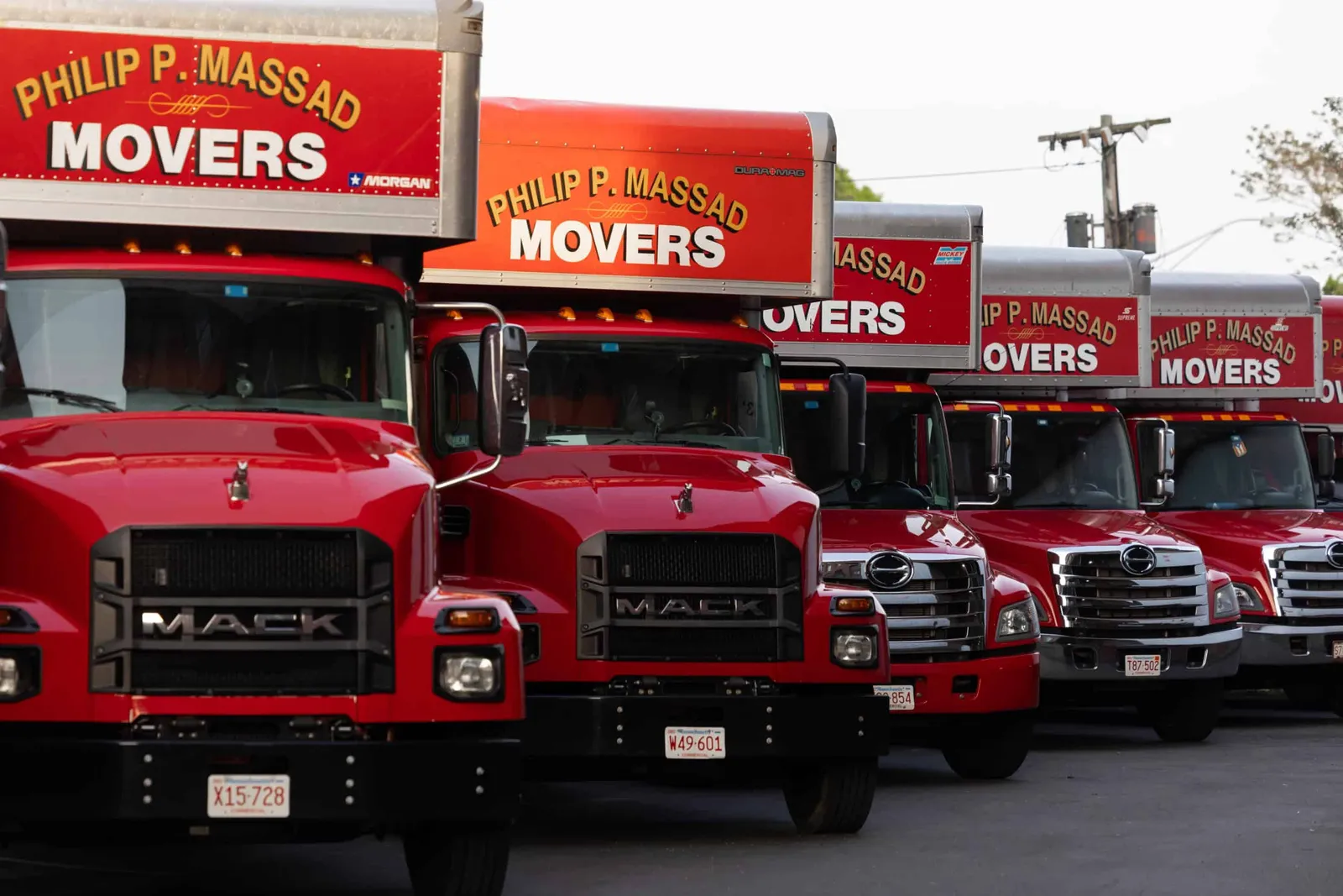 A row of red and white moving trucks parked in a parking lot.