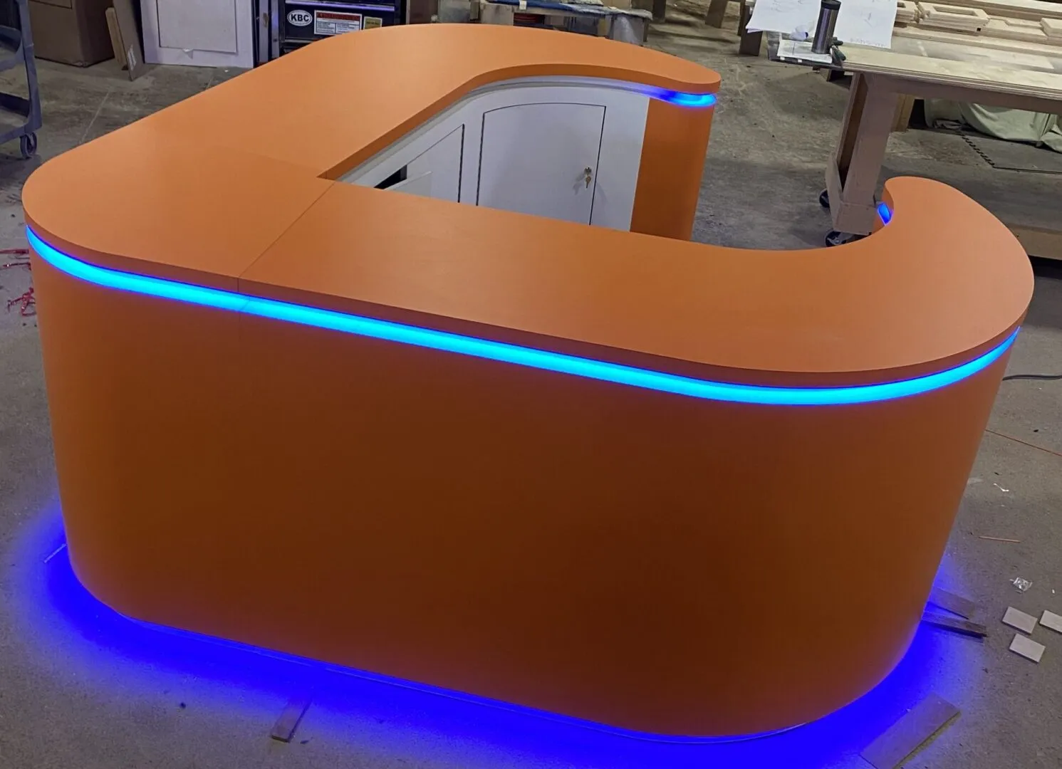 Curved orange reception desk with blue LED