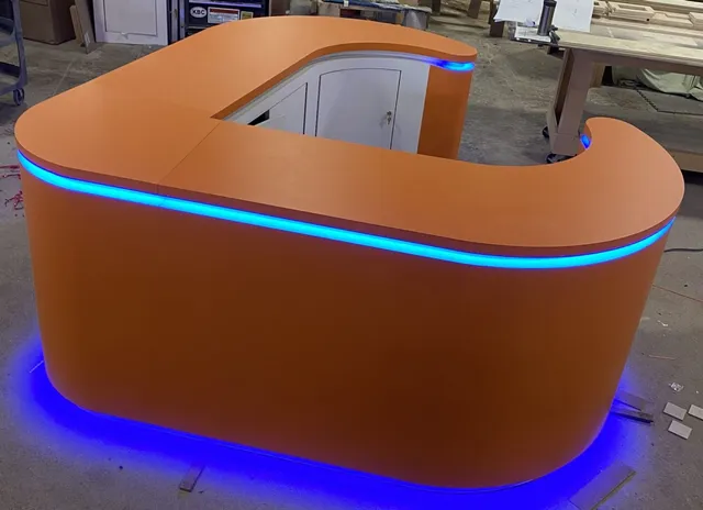 Curved orange reception desk with blue LED
