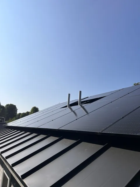 Rooftop with solar panels against a clear blue sky