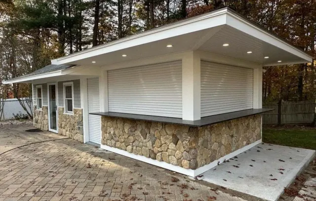 A small building with a stone wall