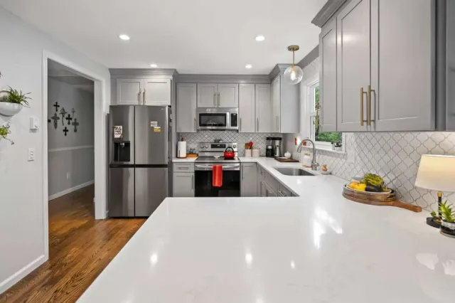 large kitchen with light gray cabinets and white peninsula countertop