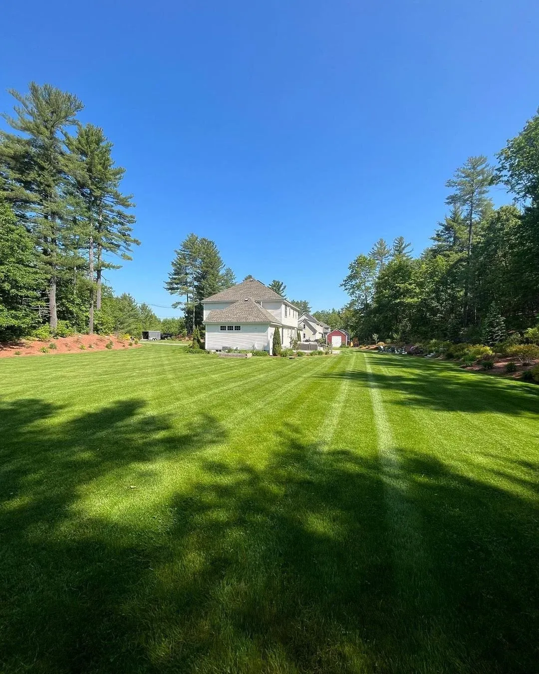 Freshly mowed backyard lawn in Groton, MA residential property by Gardner’s Landscaping, LLC