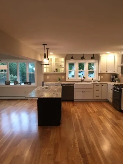 Modern kitchen with large island, light cabinets, wood floor