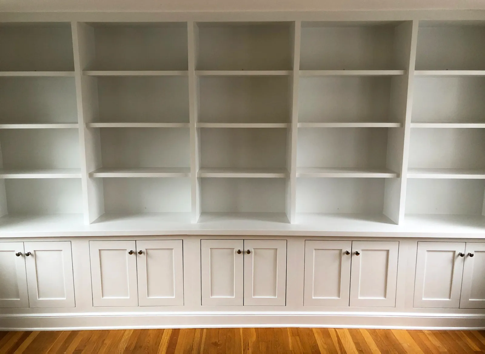A 14-foot-wide, floor to ceiling unit with shelving and cabinets with inset doors